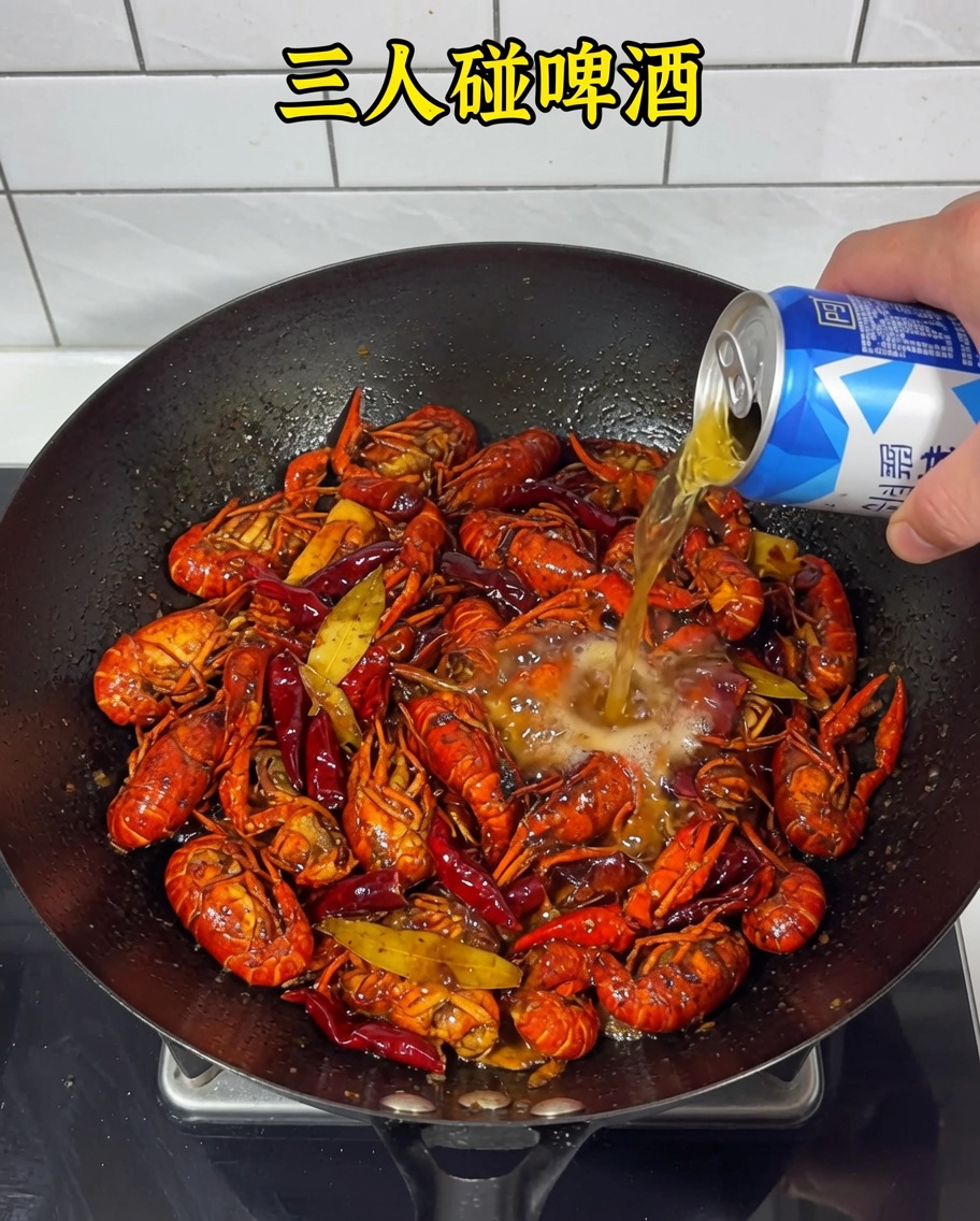 ザリガニとスパイシーなベースが入った中華鍋にビールを注いでいる様子。