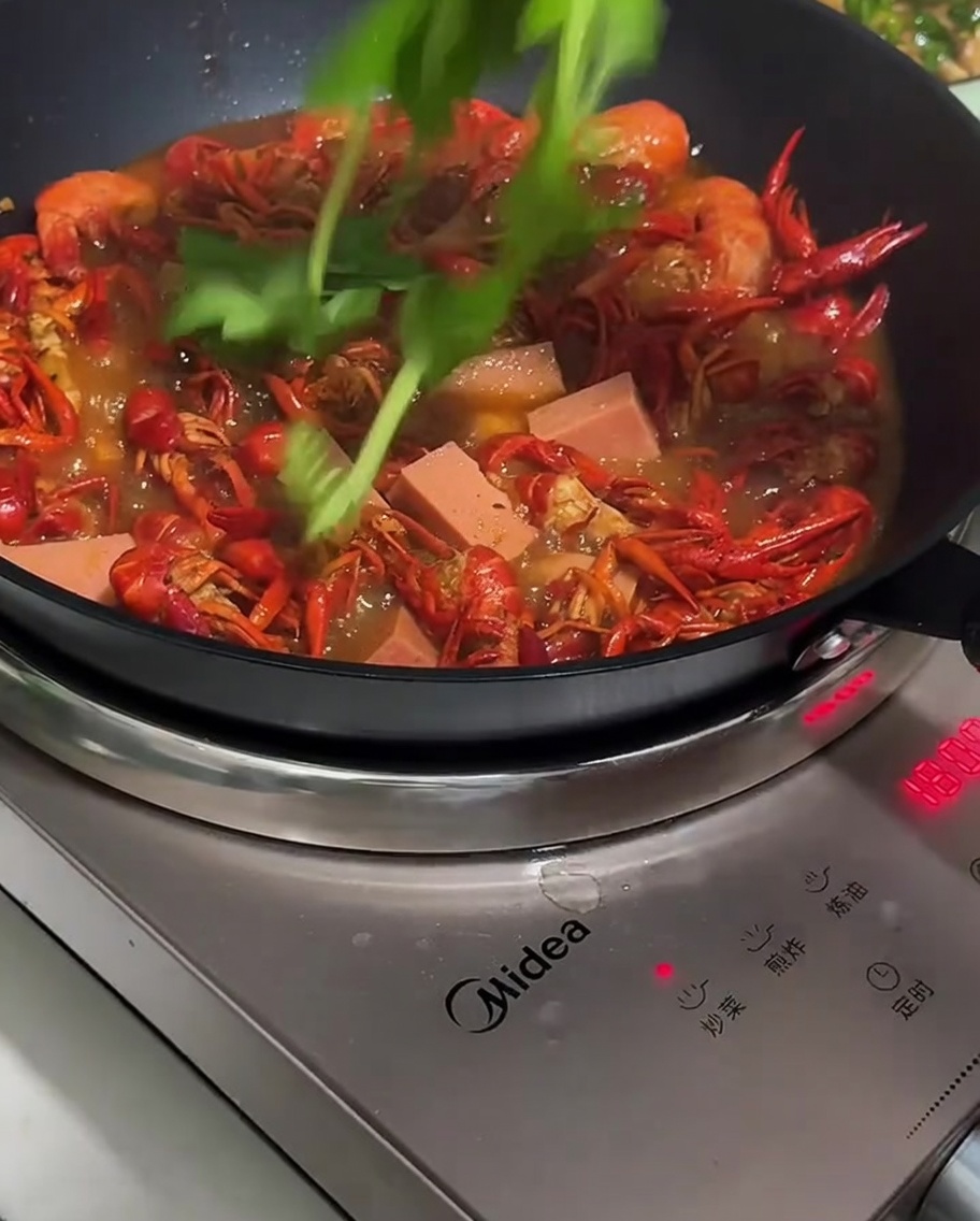 スライスしたソーセージとピーマンを鍋に加えている様子。