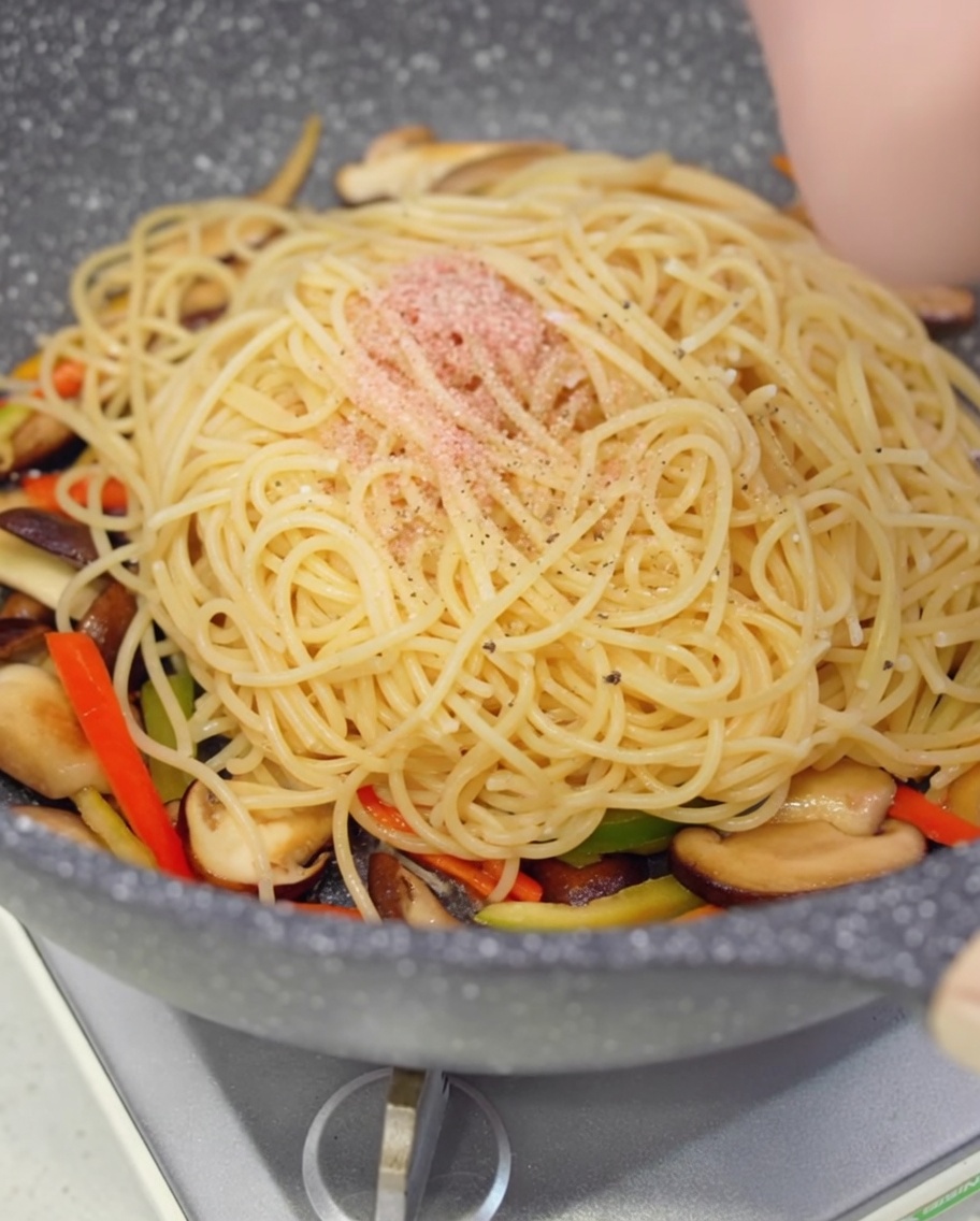 パスタに黒胡椒を挽きかけている様子。
