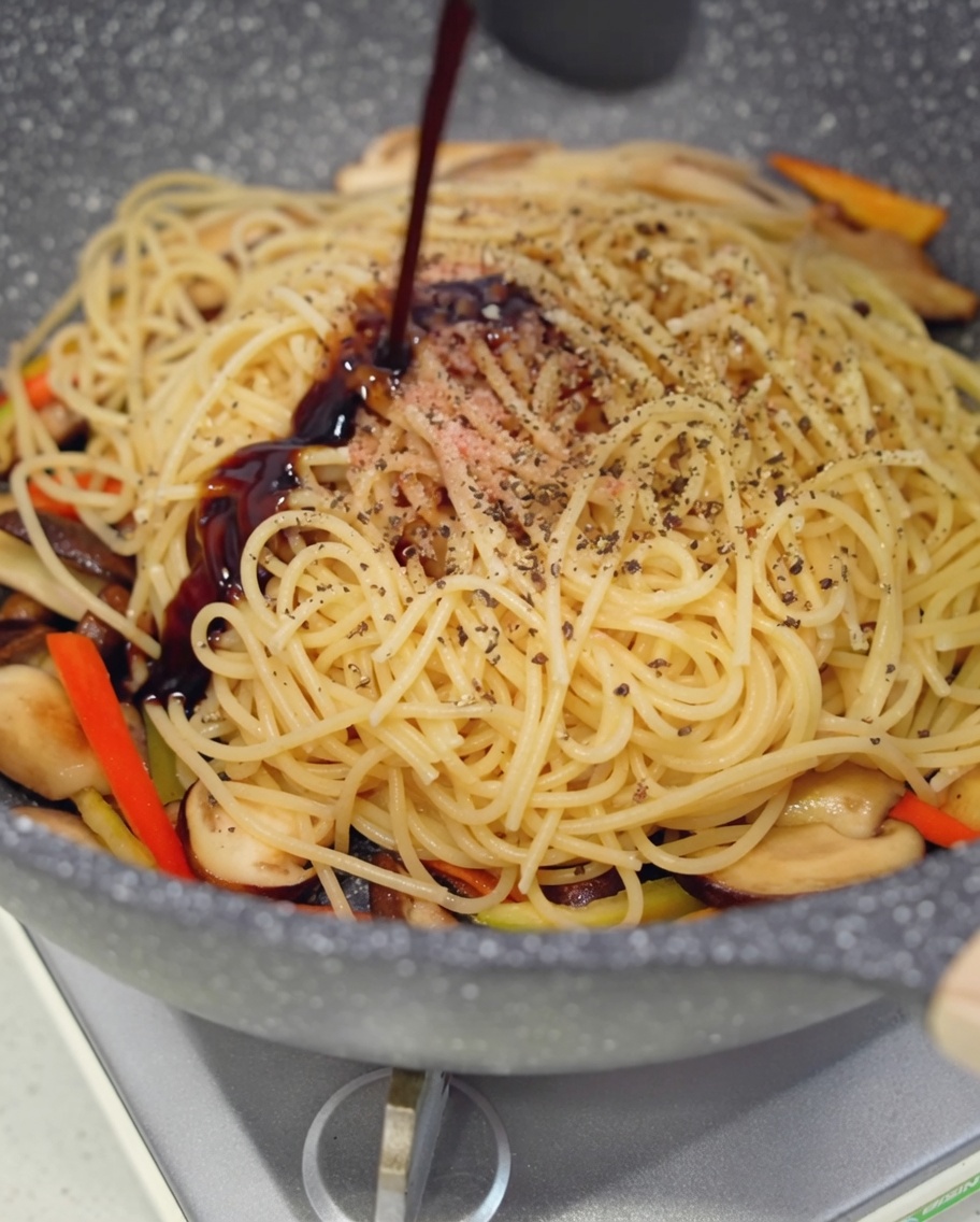 パスタにオイスターソースを回しかけている様子。