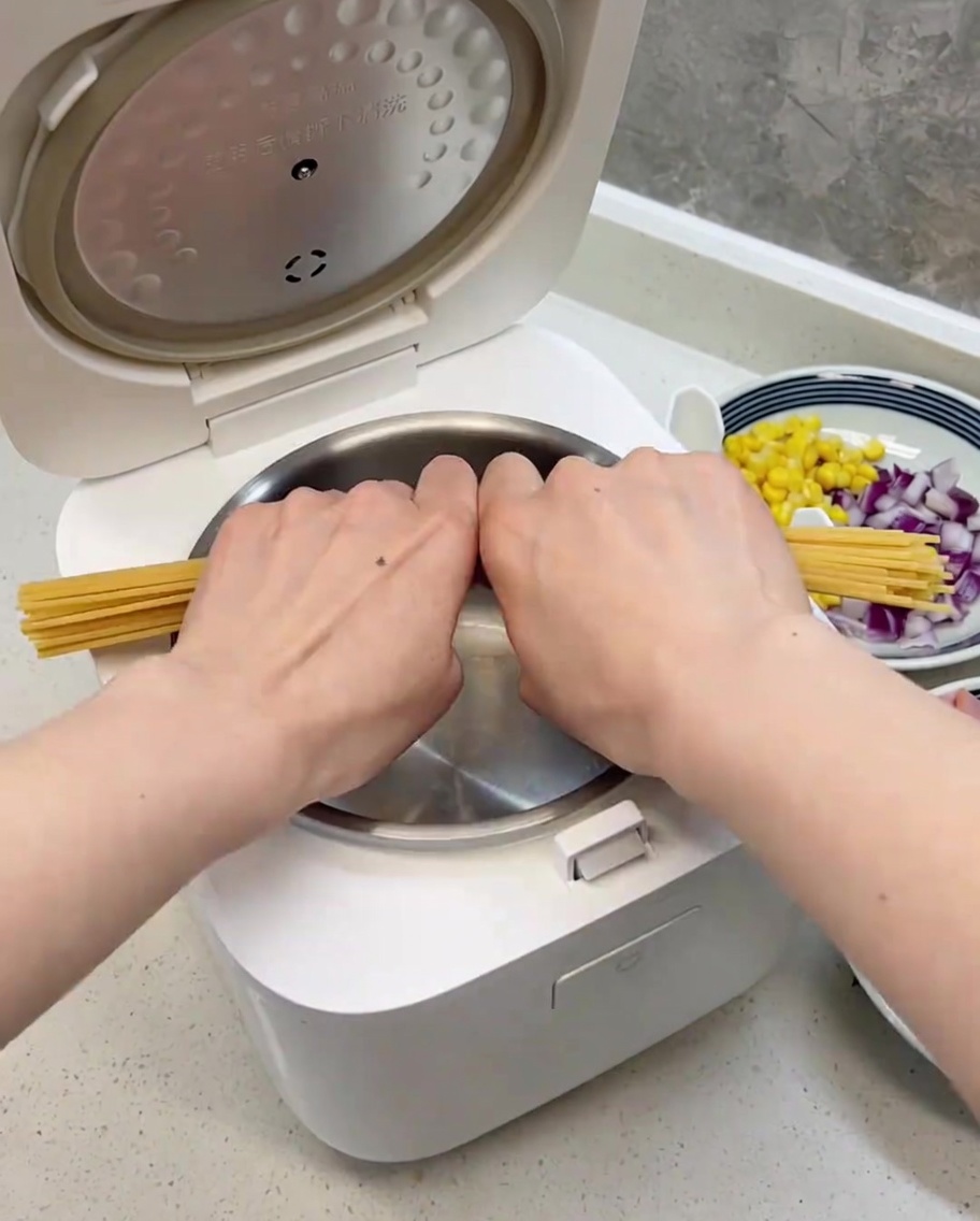 半分に折ったスパゲッティを炊飯器の内釜にきれいに並べた様子。