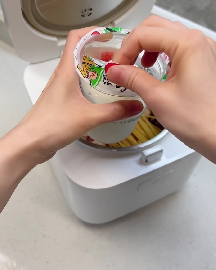 炊飯器の具材の上にクリーミーなサンデーを投入しているクローズアップ。