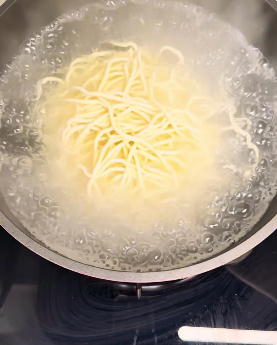 沸騰した湯で麺を茹でている様子。