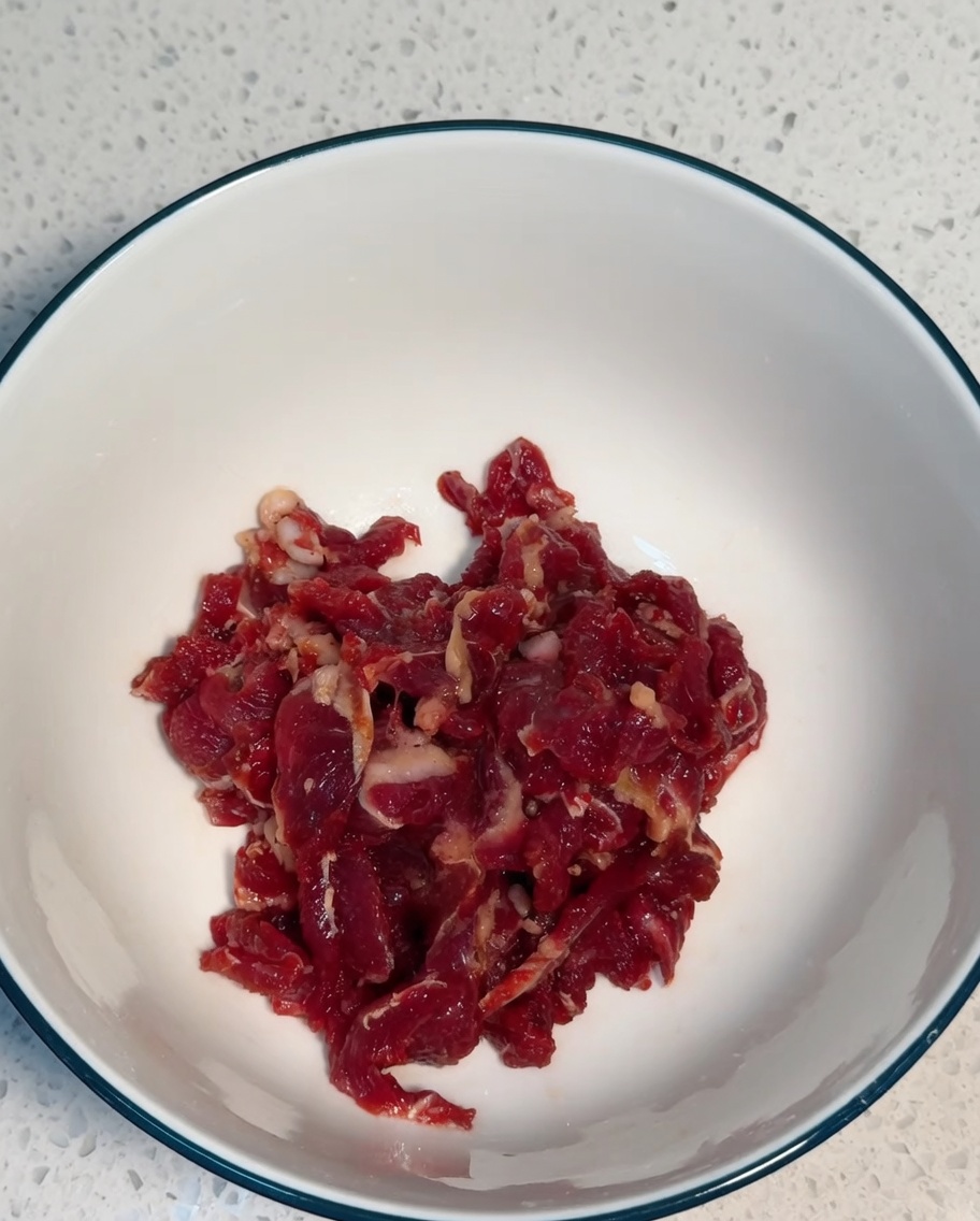 ボウルの中で牛肉と調味料を混ぜ合わせている様子。