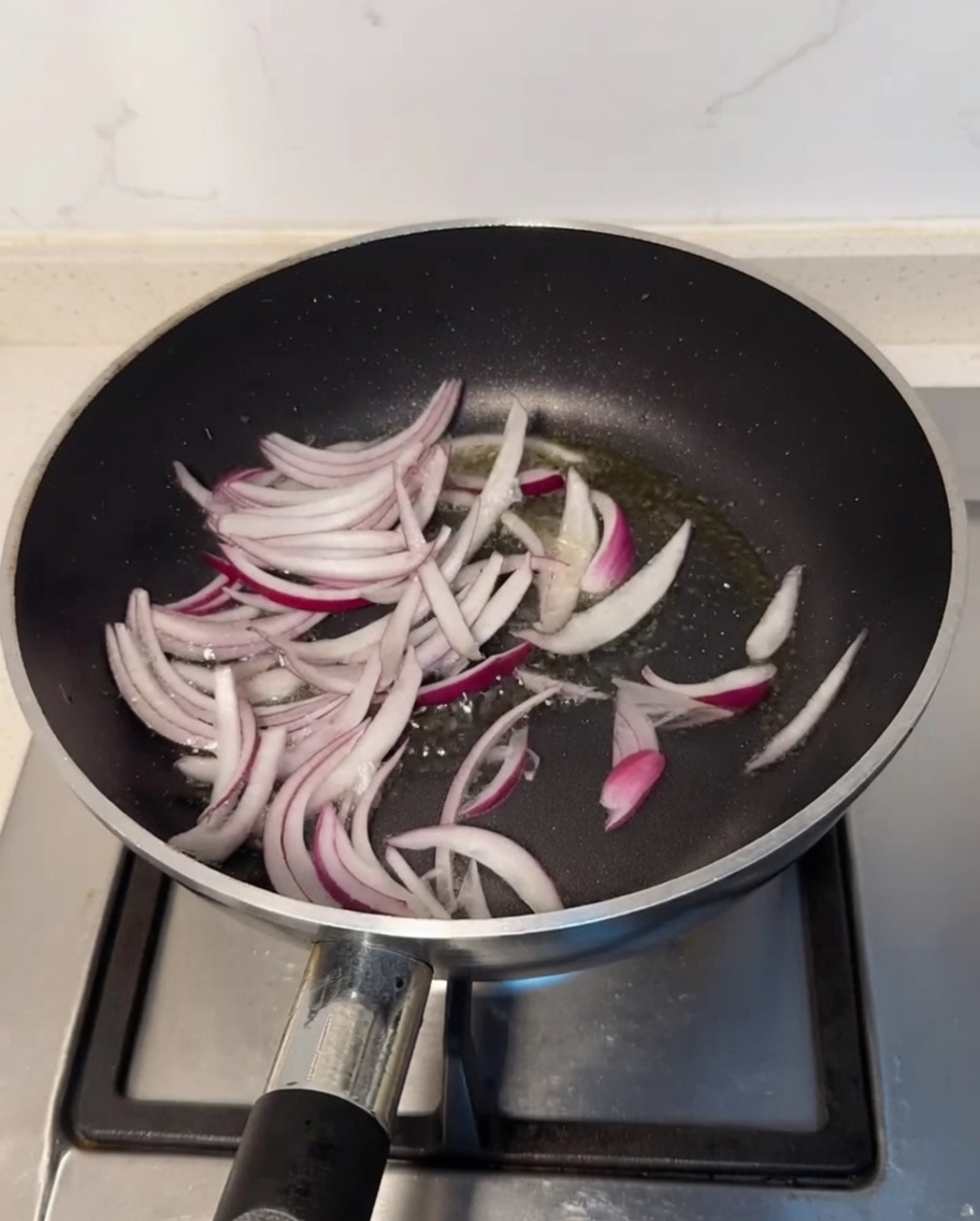 フライパンで玉ねぎを炒めている様子。