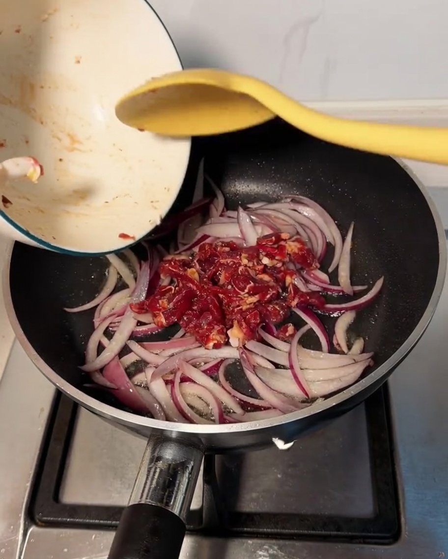 炒めた玉ねぎに牛肉を加えて炒めている様子。