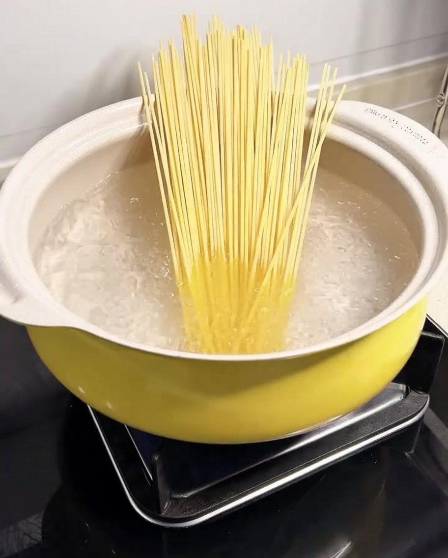 大きな鍋でスパゲッティを茹でている様子。