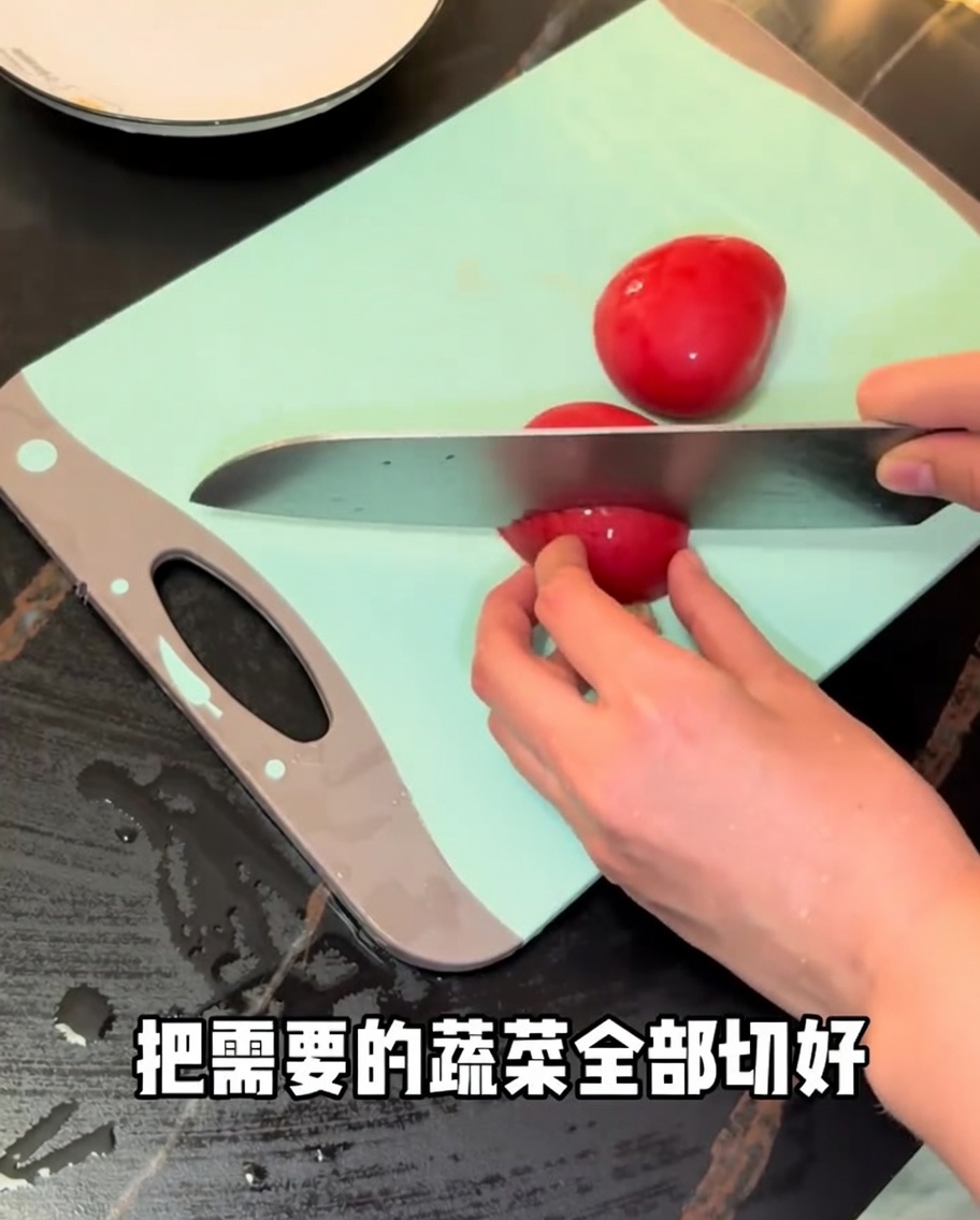 まな板の上でフレッシュトマトを包丁で切っている様子。