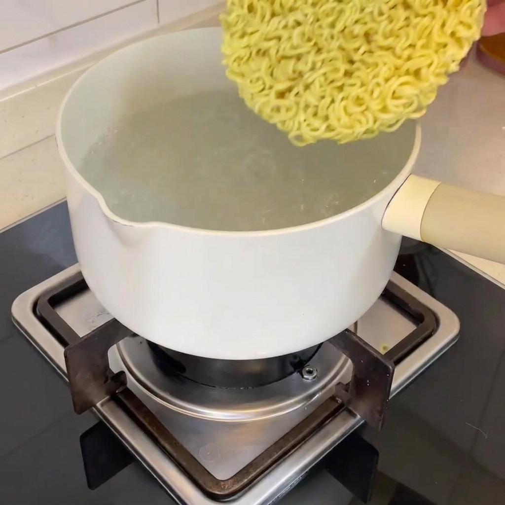 沸騰した鍋に乾燥麺を入れている様子。