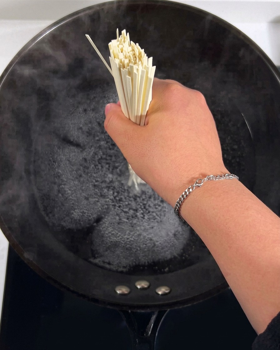 たっぷりのお湯が入った鍋で麺を茹でている様子。