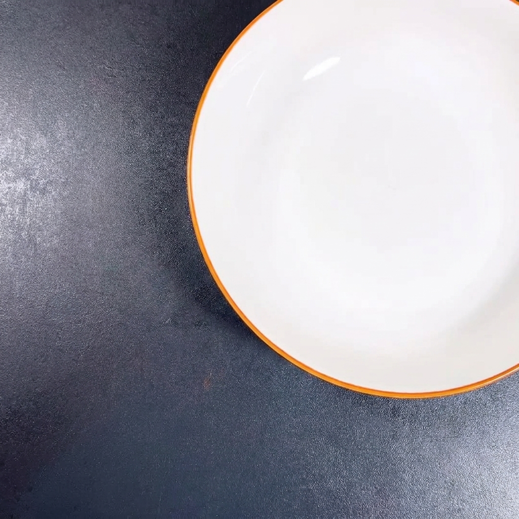みじん切りにしたにんにくと刻んだ青ねぎが入った白いボウル。