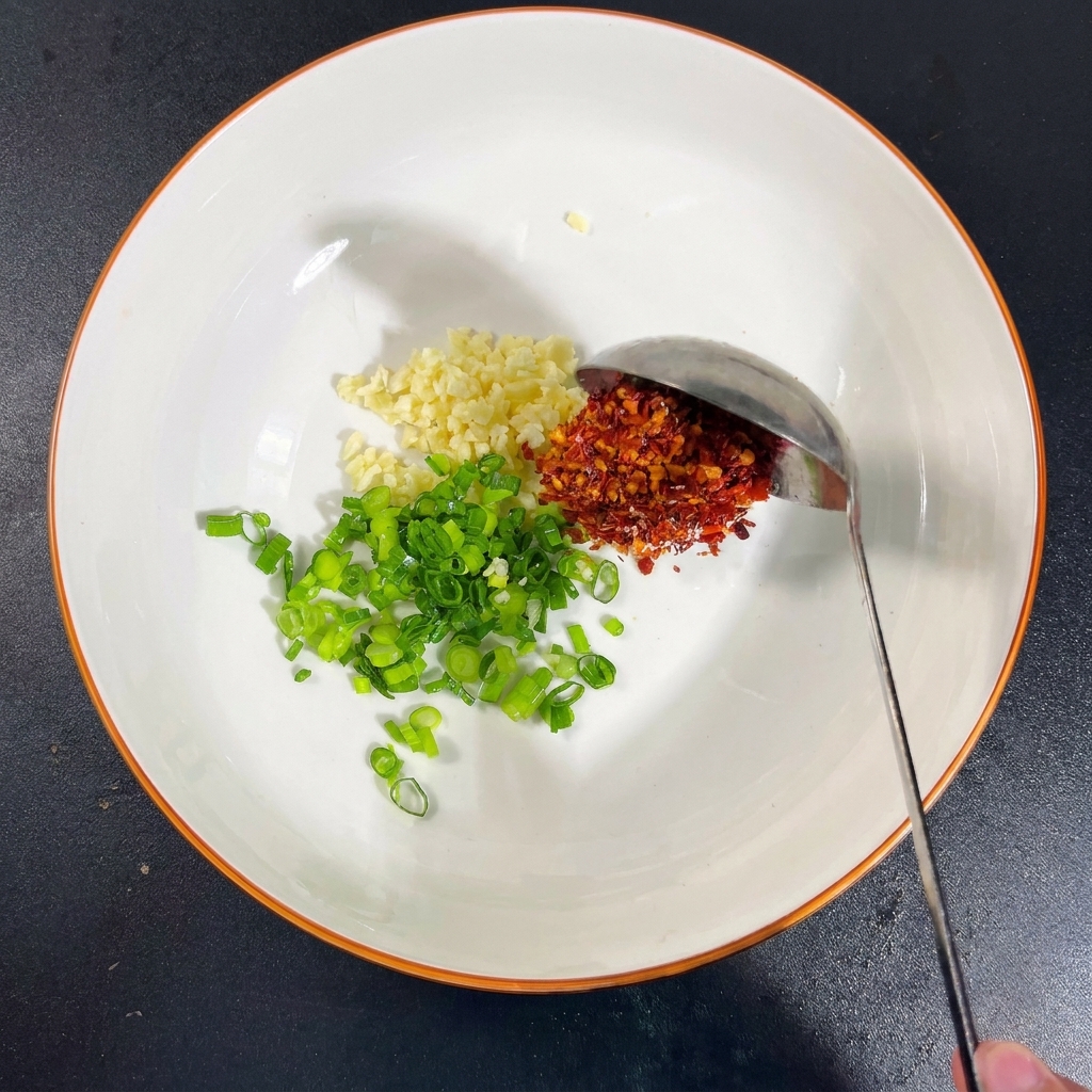 にんにく、ねぎ、塩、うま味調味料、粉唐辛子、醤油が入ったボウル。
