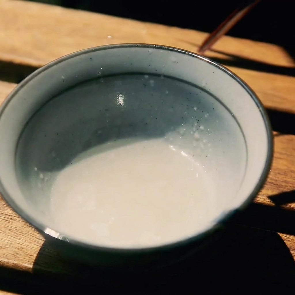 木のテーブルに置かれた、酒、砂糖、醤油が混ざった小さな器。