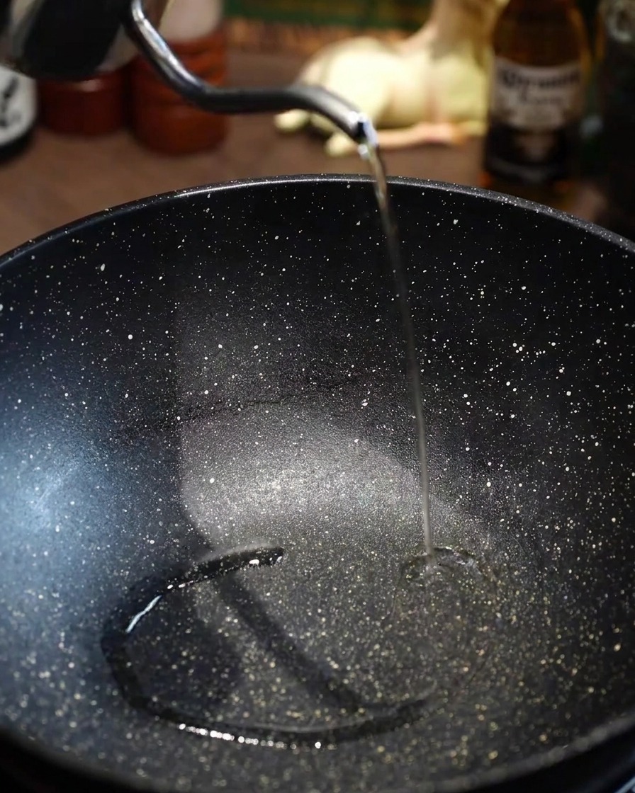 空になったフライパンを加熱し、サラダ油を引いている様子。