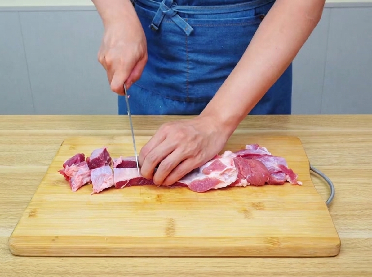 木製のまな板の上で、牛バラ肉が大きめにカットされている様子。