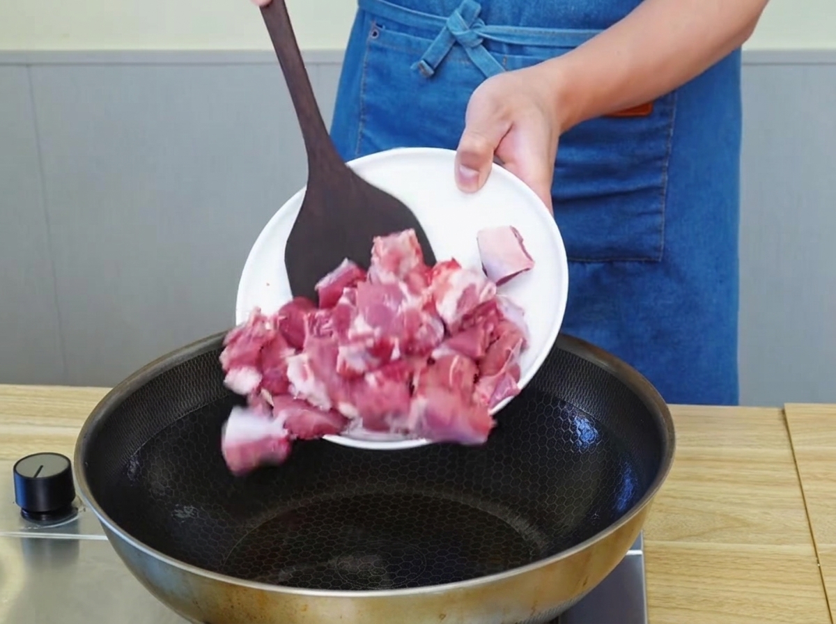 フライパンで牛肉の表面に焼き色をつけている様子。