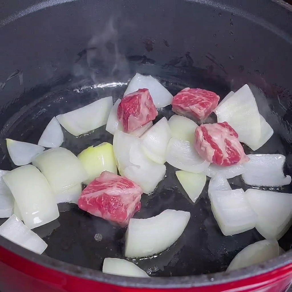 鍋で玉ねぎと牛肉を炒めている様子。