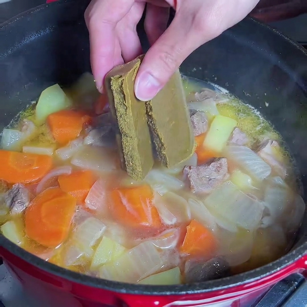 煮込んだ鍋にカレールウを入れている様子。