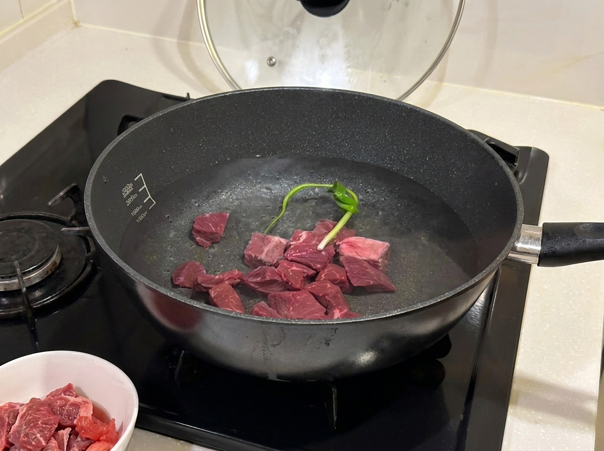 鍋で牛肉を香辛料と料理酒と共に茹でている様子