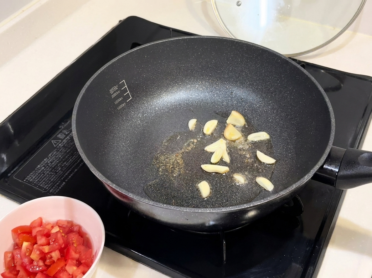 フライパンでスライスしたにんにくを炒めている様子