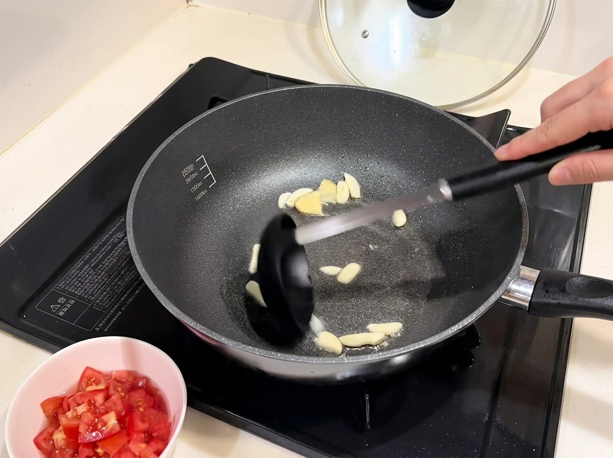 にんにくと共に赤玉ねぎを炒めている様子