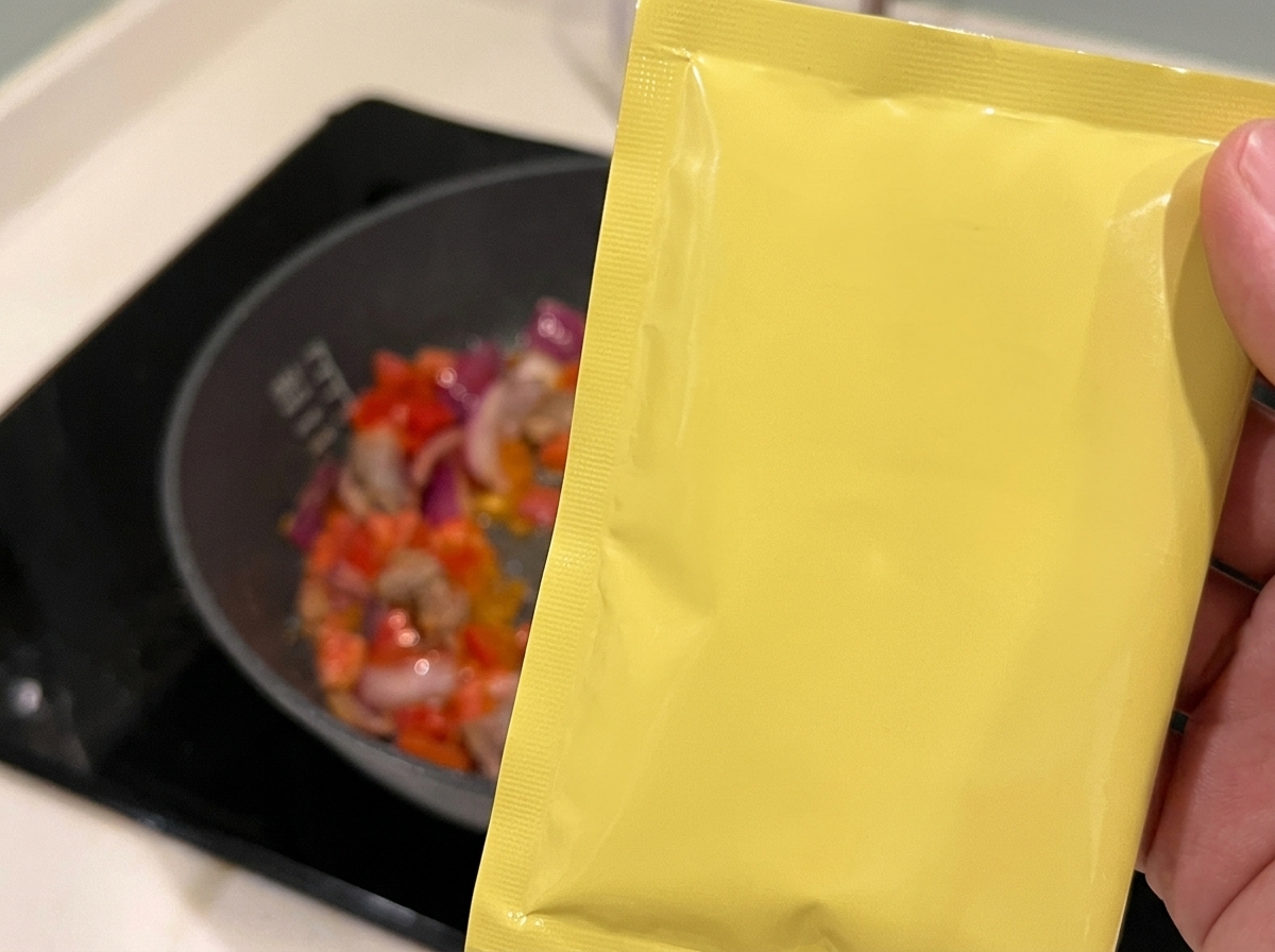 炒めた具材に料理酒を回し入れている様子