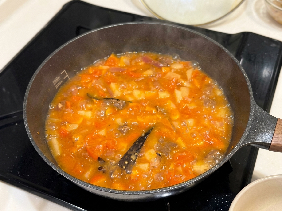 煮汁にカレールーを溶かし入れている様子