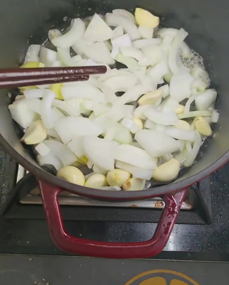 鍋で玉ねぎとにんにくを炒めている様子