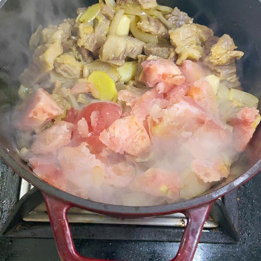 鍋に冷凍トマトを加えている様子