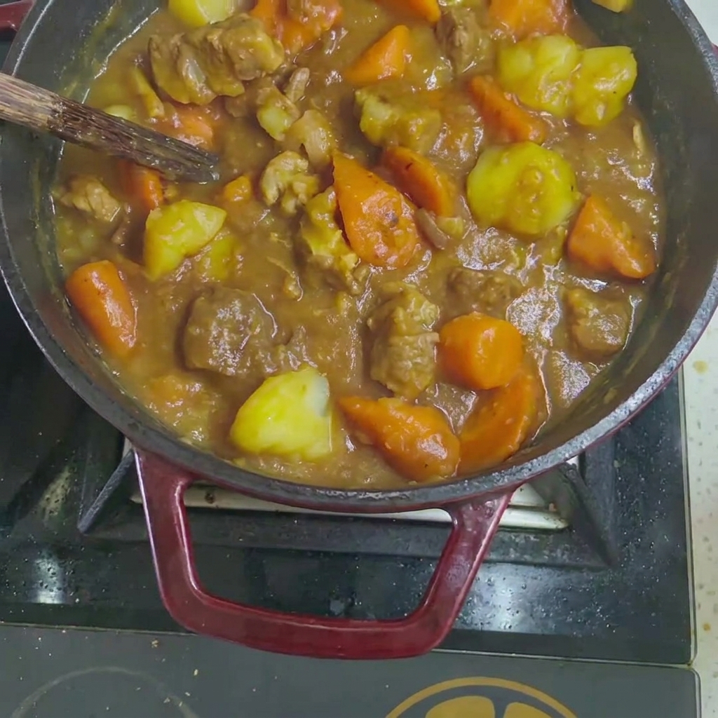 煮込み鍋にカレールーを入れる様子