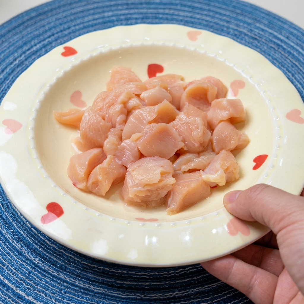 ボウルに入れた一口大の鶏むね肉に、醤油や料理酒、香辛料を加えている様子。