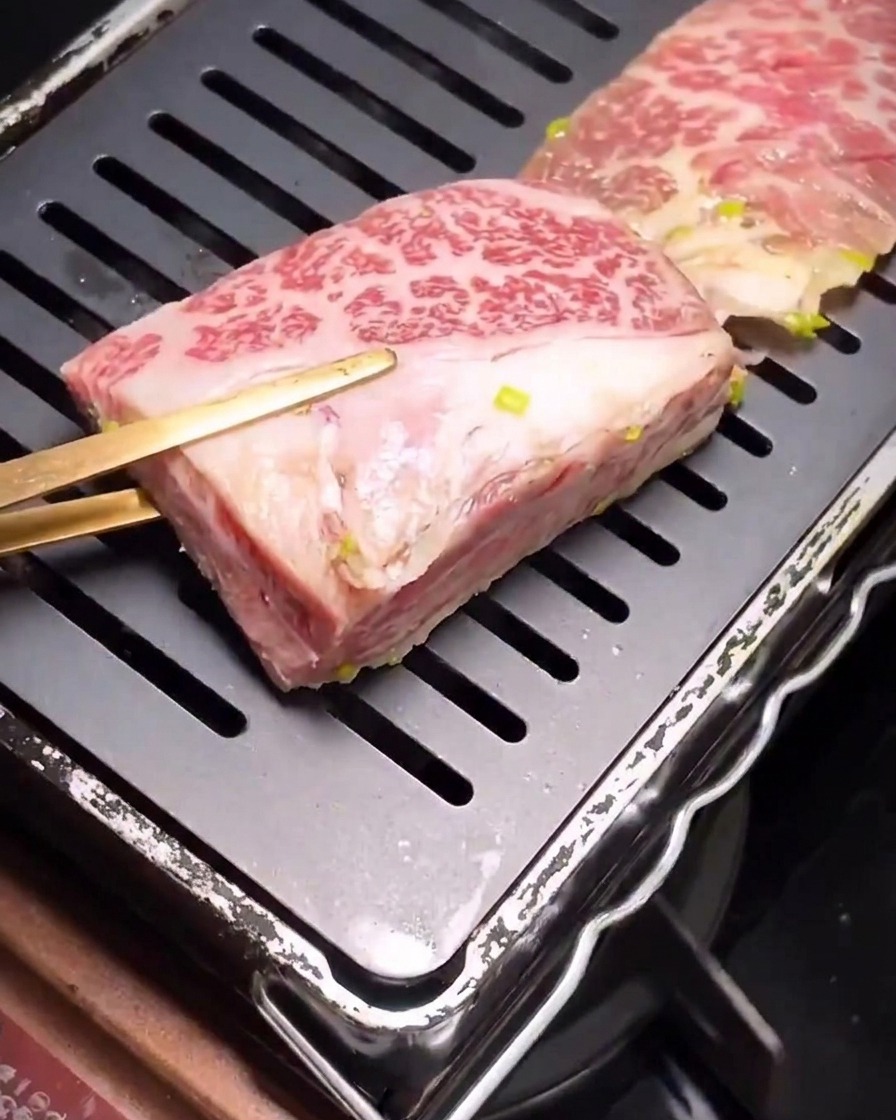 熱した波型グリルパンで焼かれ始めた漬け込み済みの牛カルビ肉