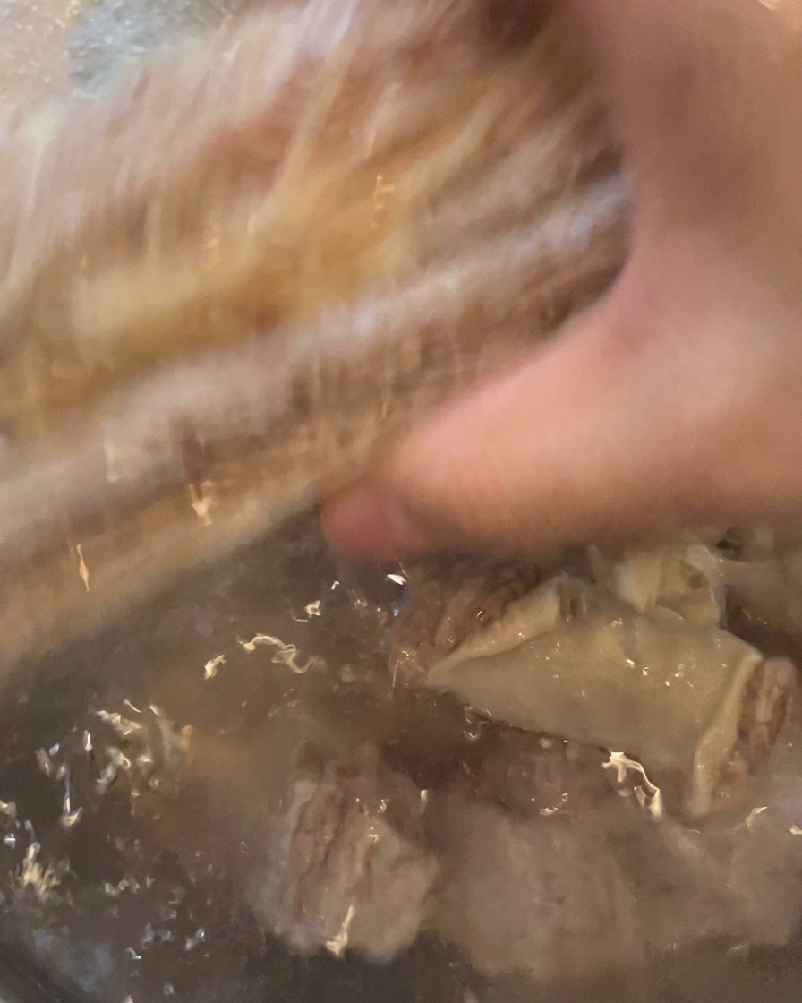 下茹で後のカルビを流水で丁寧に洗っている様子。