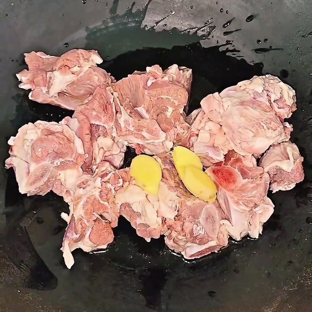 生姜スライスと料理酒を加えた鍋で牛スペアリブを下茹でしている様子。