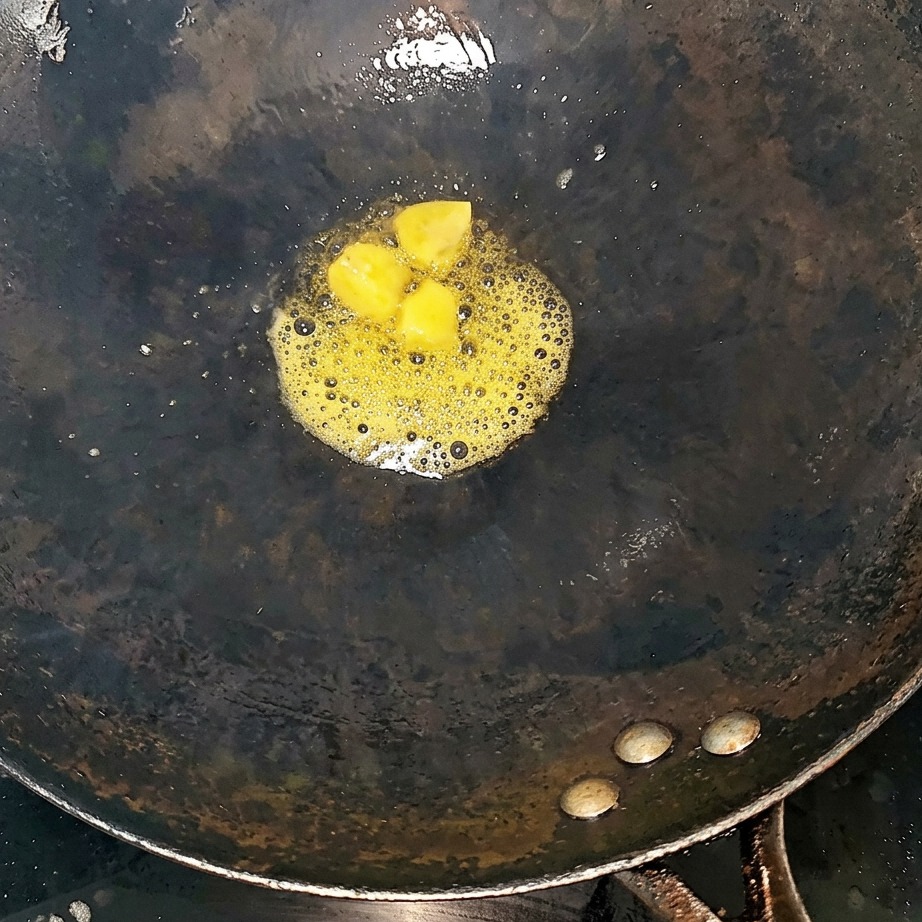 熱した中華鍋で牛スペアリブと生姜スライスを炒めている様子。