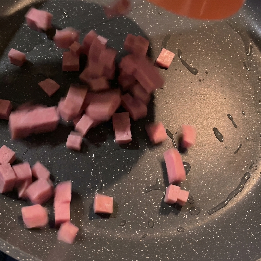 フライパンでスパムがこんがりと焼けている様子。
