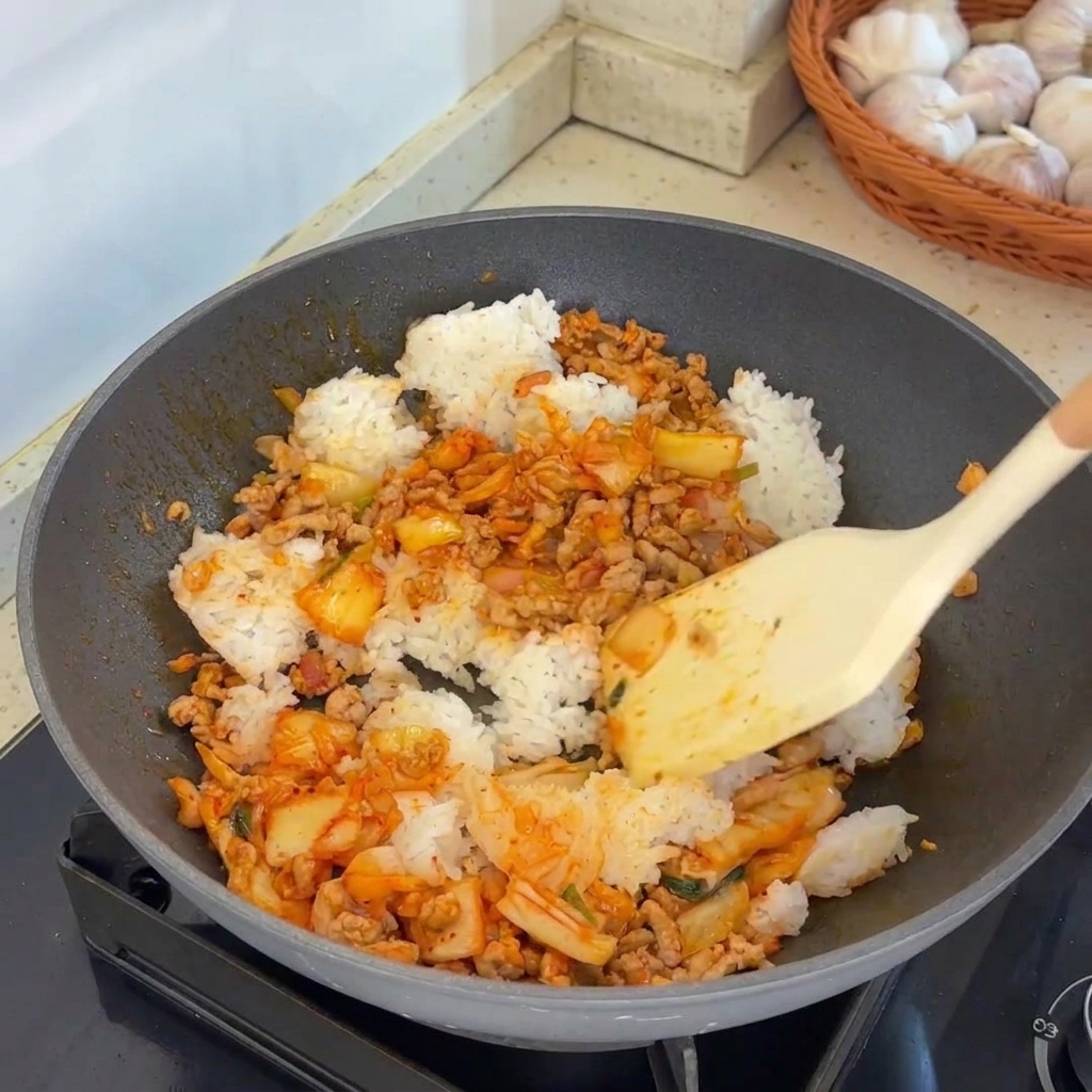 熱した中華鍋で、ご飯と具材を勢いよく炒め合わせている様子。