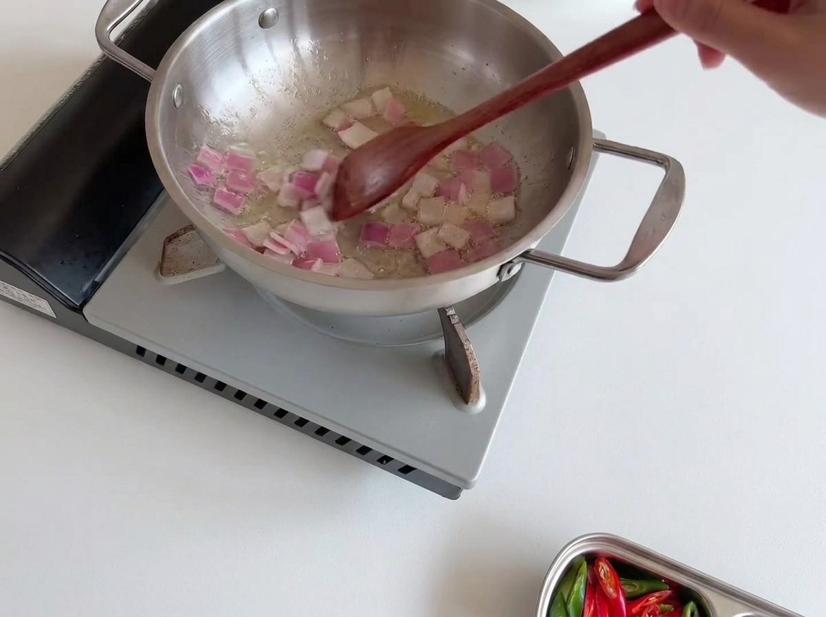 炒めた玉ねぎの上に白いえのき茸を均等に広げた様子