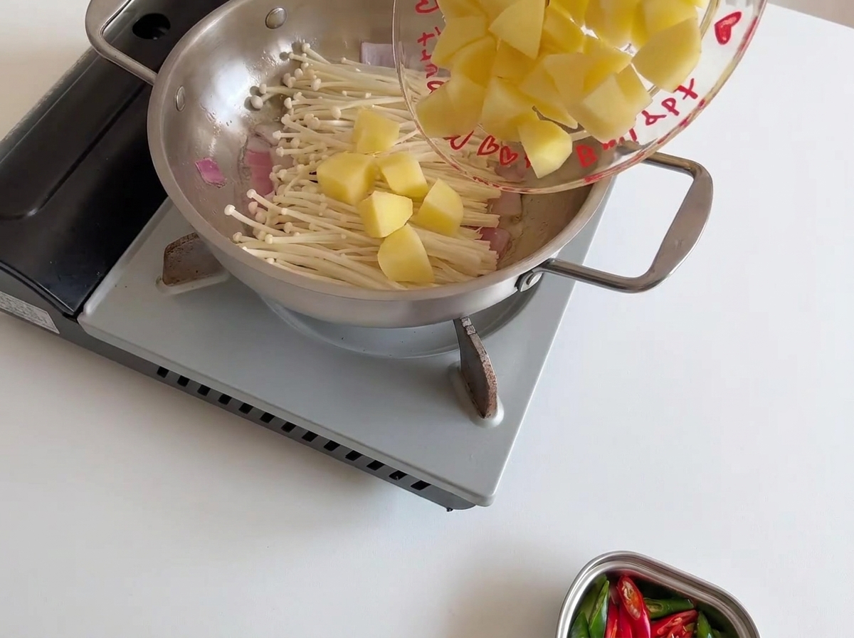 えのき茸の上に乱切りにした生のじゃがいもをのせた様子