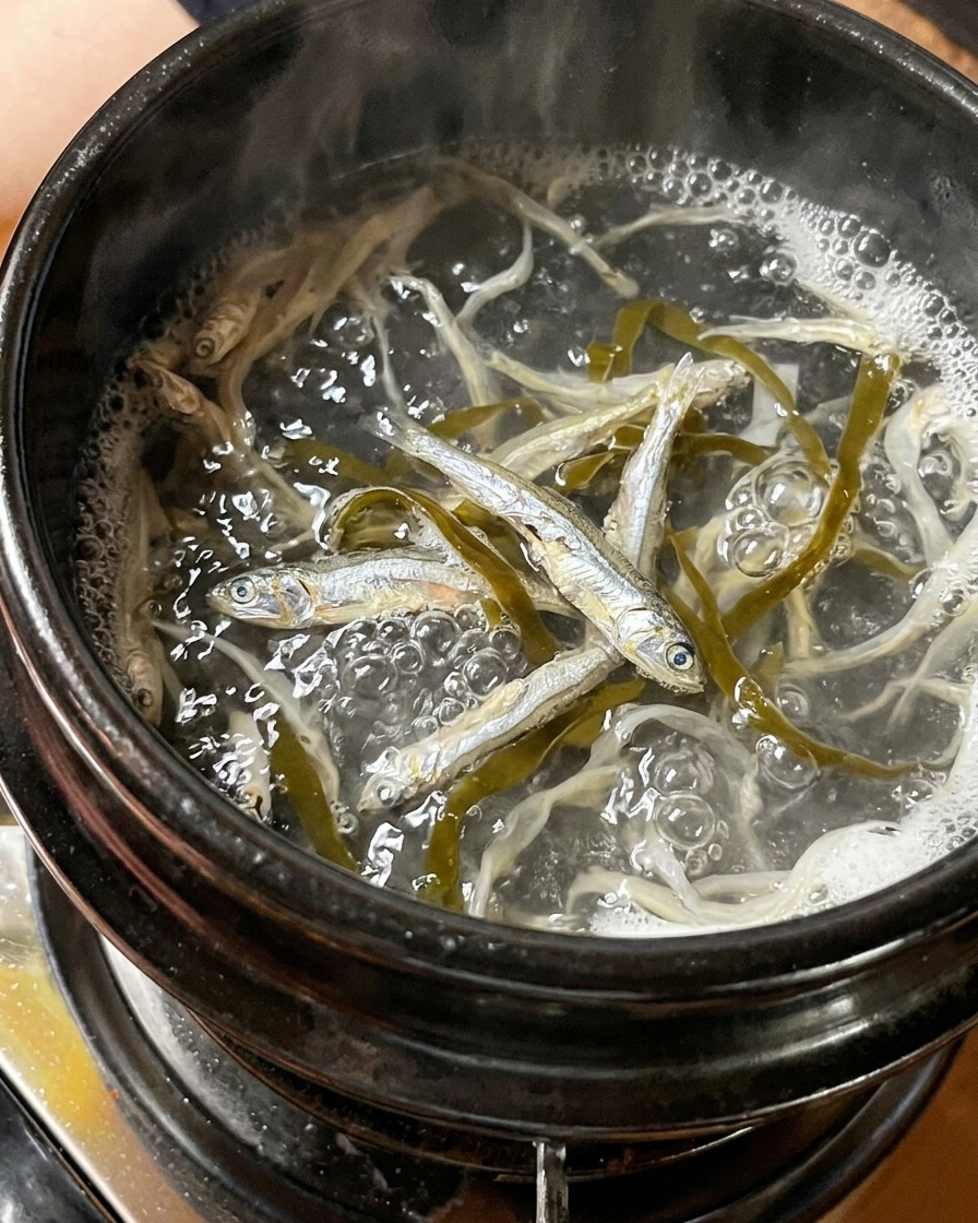 水を入れた鍋で煮出されている煮干しと昆布。