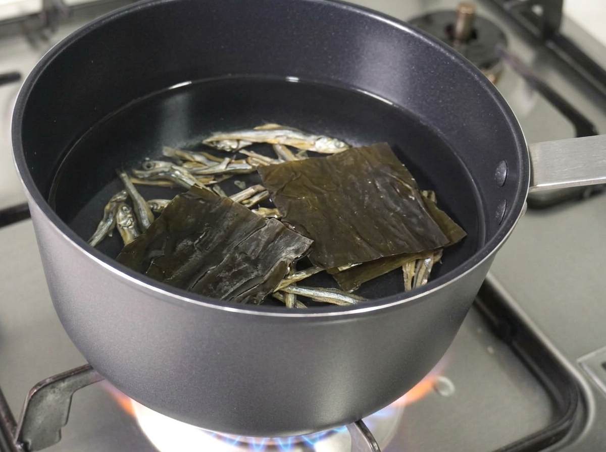 鍋の水の中に煮干しと昆布を浮かべている様子。
