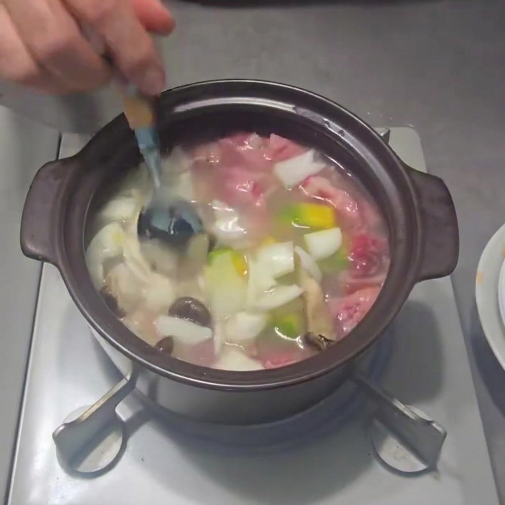 小口切りにした長ねぎを鍋に散らす様子。