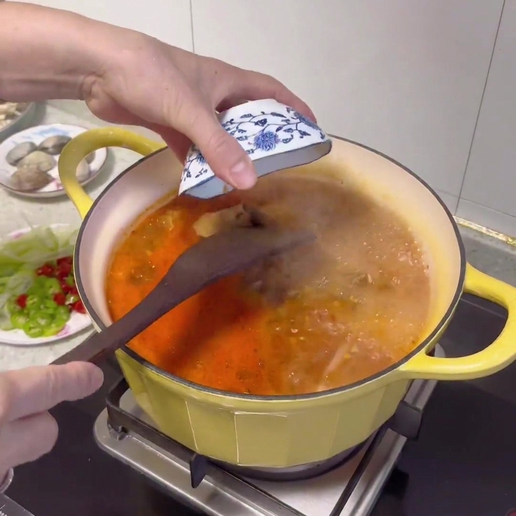 沸騰したスープに、木のスプーンで韓国味噌を加えている様子。