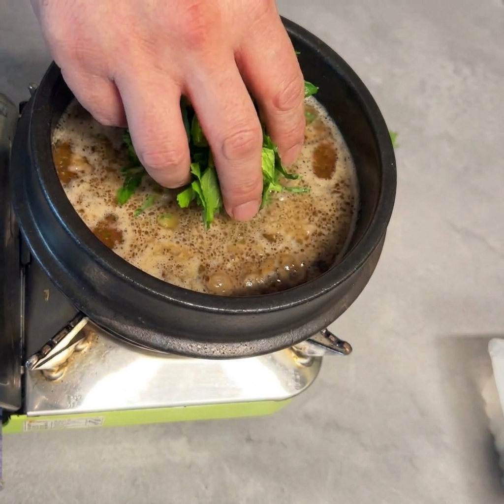 スープの中に新鮮なチンゲン菜が入れられている様子。