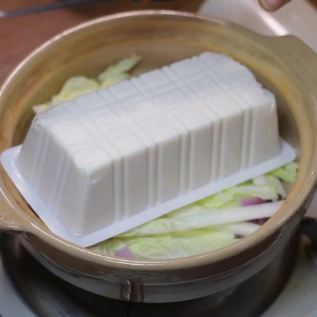 野菜の上に絹ごし豆腐を丁寧に並べている様子。