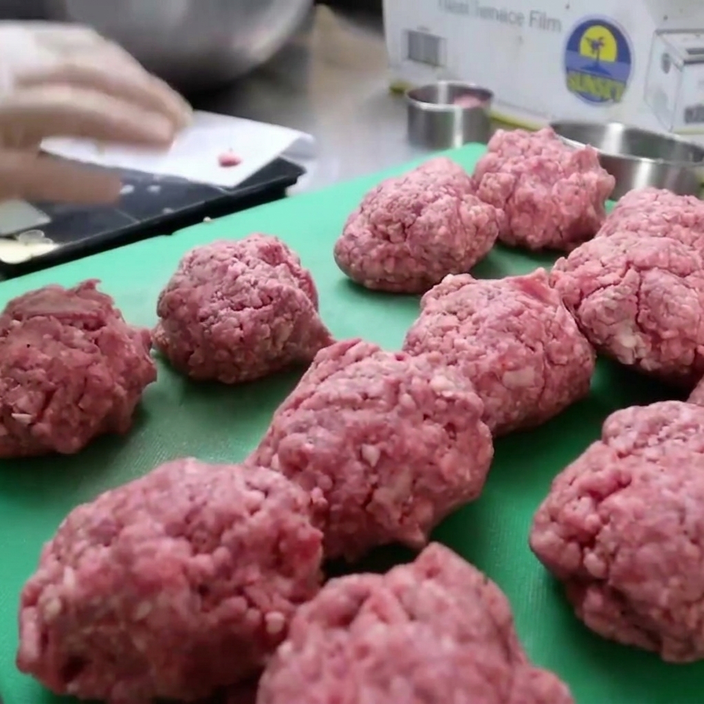 バイソンひき肉を丸い型に入れて、厚みのあるバーガーパティに成形している様子。