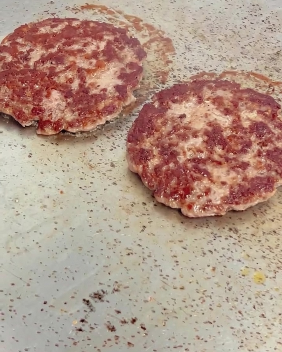 焼き上がったパティの上にチェダーチーズをのせ、溶かしている様子。