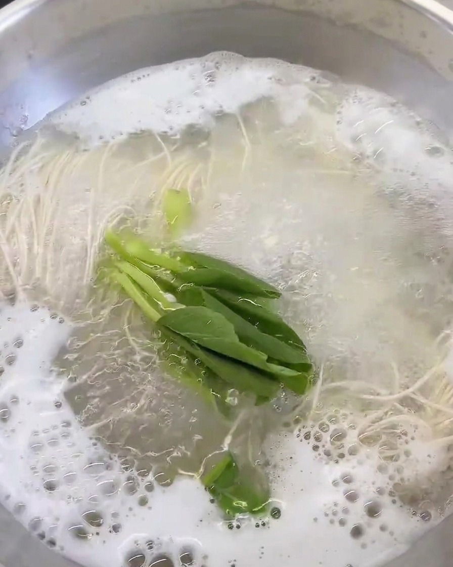 スープの中で青菜をサッと茹でている様子。