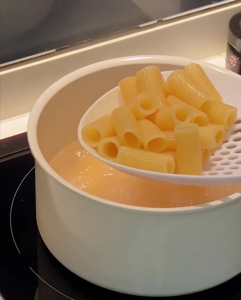 穴あきお玉ですくい上げられる、茹で上がったリガトーニ。