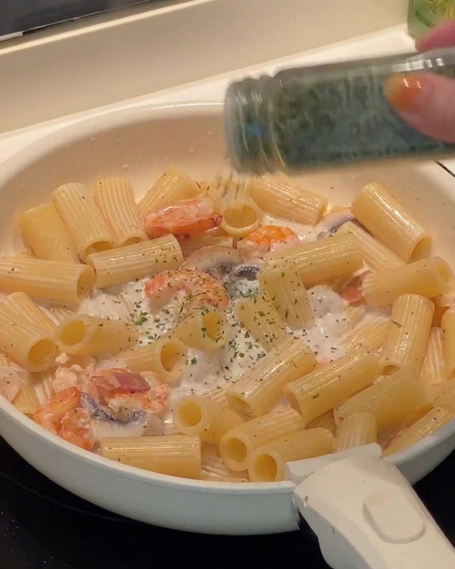 調理の最後に、刻んだパセリを散らした完成間近のパスタ。